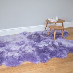 a purple rug on the floor next to a table