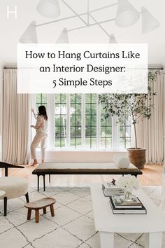 a woman standing in front of a window with the words how to hang curtains like an interior designer 5 simple steps