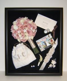 a bouquet of flowers and other items in a black frame