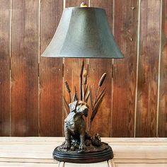 a lamp that is sitting on top of a wooden table in front of a wall