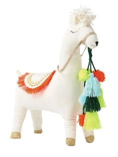 a stuffed animal with tassels attached to it's neck and tail, standing upright on a white background