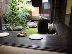 a table with two plates on top of it in front of some rocks and grass