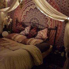 a bed with lights hanging from the ceiling above it and a chandelier in the corner