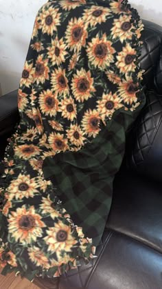 sunflowers on black and green flannel blanket sitting on a leather chair