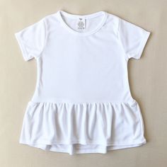 Infant Girls Short Sleeve Peplum T-shirt Top with Tearaway Label.  White 100% Polyester Interlock Knit 6.0 oz weight. Super-soft touch Interlock knit is great for Embroidery, Sublimation, Screen printing, Direct to Garment and Heat Transfer Vinyl.   Relabel with your Brand and Let your Creativity Flow!  Available in Sizes: 3-6mths, 6-12mths, 12-18mths, 18-24mths Neck Label must be removed before wearing. Even though it is secured on the seam, it is not meant to remain on garment when worn. Cute Short Sleeve Stretch Tops, Cute Stretch Short Sleeve Tops, Cute Solid Short Sleeve Tops, Cute Stretch Short Sleeve T-shirt, Short Girls, T Shirt Top, Knit Top, Adult Outfits, Tops & Tees