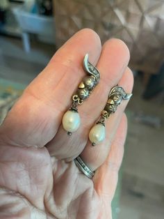 "Circa approx. 1800 Stunning Rose Cut Diamond Genuine Pearl earrings. ONE OF A KIND 2 larger rose cut diamonds set into silver which was customary during that era - one approx. 3.5mm (top) and (Bottom) 2.75mm There are 4 rose cuts in the \"swirl\" above measuring 1.5-2.5mm each Total diamond ESTIMATE weight .70ct. There are two natural cream colored pearls approx. 9 x 7.5mm dangling below which may have been replacement pearls as they show no wear. 1 1/4\" top to bottom including the wire 14k ye Victorian Hallmarked Pearl Earrings As Gift, Victorian Style Drop Pearl Earrings, Hallmarked Sterling Silver Dangle Pearl Earrings, Victorian Pearl Earrings For Anniversary, Silver Victorian Earrings For Anniversary, Rose Gold Sterling Silver Pearl Earrings, White Victorian Dangle Jewelry, Antique Silver Pearl Earrings For Anniversary, Fine Jewelry Sterling Silver Pearl Earrings