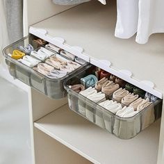 two plastic storage containers filled with socks and other items on top of a white dresser