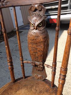 an owl statue sitting on top of a wooden chair