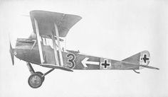 an old airplane flying in the sky with two crosses on it's side and one wing