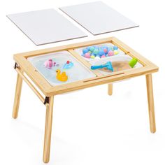 a wooden table with two trays on it and some toys in the middle one