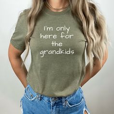 I Only Came For The Grandkids Shirt Grandma Shirt Grandpa Shirt Gifts for Grandparent Funny Grandma Shirt Grandma Life Grandpa Tshirt MATERIAL: - Solid colors are 100% cotton except Ash - 99% cotton and 1% polyester - Heather colors and Solid Black Blend are 52% cotton, 48% polyester (personal favorite feel👌 won't shrink as much after dryer) - Athletic Heather and Black Heather are 90% cotton, 10% polyester The Relaxed Fit T-Shirt (Bella + Canvas design 3001) is a unisex style that runs slightl Mother's Day Crew Neck Tops With Funny Text, Family Matching Tops With Funny Text, Funny Print Crew Neck Top For Mother's Day, Funny Short Sleeve Tops For Mother's Day, Mother's Day Cotton Slogan Tops, Fun Green Tops With Text Print, Fun Green Top With Text Print, Fun Crew Neck Top With Name Print, Family Matching Slogan Tops For Mother's Day