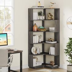 a room with a computer desk and book shelf