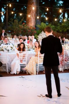 a man standing next to a woman on top of a dance floor at a wedding