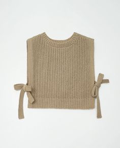 a sweater with ties on the side and a knitted top that has a bow at the back