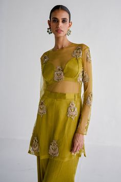 Lime net kurta with floral zardosi embroidery . Paired with bralette and same colored pant.
Components: 3
Pattern: Embroidered
Type Of Work: Zardosi
Neckline: Round
Sleeve Type: Full
Fabric: Net, mashru satin, Lining: Shantoon
Color: Green
Other Details: 
Net kurta
Note: The brown outfit worn by the model is not for sale
Occasion: Puja - Aza Fashions Mehendi Outfit, Zardosi Embroidery, Stylish Kurtis Design, Latest Dress Design, Simple Pakistani Dresses, Draped Skirt, Trendy Fashion Tops, Party Wear Indian Dresses, Brown Outfit