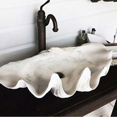 a bathroom sink sitting on top of a wooden counter next to a faucet