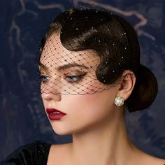 a woman wearing a black veil with pearls on it's head and her hair in a bun