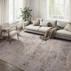 a living room with a couch, chair and large rug in front of two windows