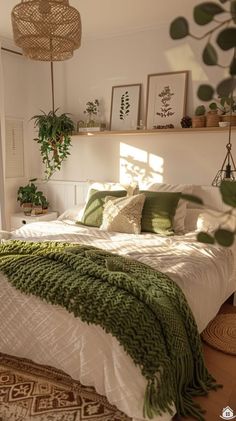 a bed with green and white blankets on top of it next to a potted plant