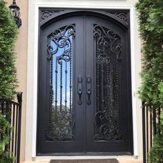 the front door to a home with wrought iron doors