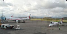 two airplanes parked on the tarmac at an airport