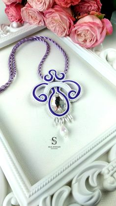 "Soutache Pendant, floral design.  Very fashionable, elegant and incredible handmade Soutache Pendant. Pendant made of very high quality soutache strings, Drop Crystal Swarovski Pendant decorated with crystals drops, pearls and beads. Color: White-Purple Length Pendant: \"3.7\" in, 9.5 cm Length with strap: \"12.9\" in, 33 cm Back: Natural leather Pendant handmade with Love. All the jewelry Silk Jewelry accessories are modern and elegant. You can turn an into charming princesses with it. Thank you for visiting" Statement Earrings Bride, Soutache Pendant, Leather Pendant, Swarovski Pendant, Soutache Necklace, Silk Jewelry, Green Pendants, Hand Painted Decor, Red Pendants