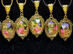 four necklaces with pictures of flowers and birds on them, all in gold tone