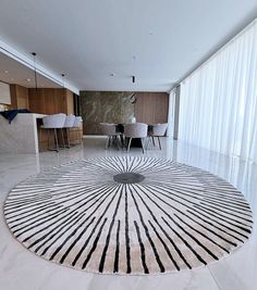 a circular rug in the middle of a living room with chairs and tables on either side