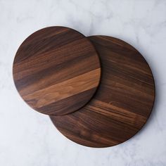 two wooden cutting boards sitting on top of a white counter