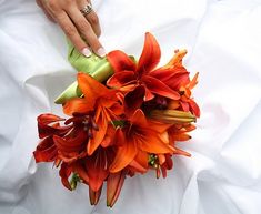 the bride's bouquet has orange lilies in it