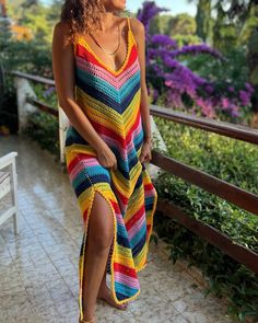 a woman in a colorful dress standing on a balcony