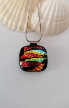 a glass pendant is sitting on a shell