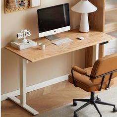 a computer desk with a chair, lamp and pictures on the wall