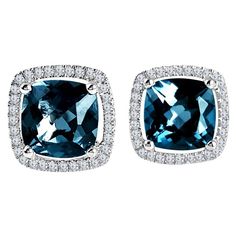 Introducing these exquisite halo stud earrings, a true testament to elegance and luxury. These earrings are a stunning showcase of London Blue Topaz and white diamonds, expertly crafted to captivate the heart and enhance your style. London Blue Topaz Radiance: At the heart of these earrings, you'll find two cushion-cut London Blue Topaz stones totaling a remarkable 3.73 carats. The enchanting London Blue Topaz gemstone is renowned for its deep, rich blue color, reminiscent of the serene ocean de Cushion Cut Earrings, Halo Diamond Earrings, Halo Stud Earrings, Diamond Collection, White Gold Set, Halo Earrings, Blue Topaz Stone, Blue Topaz Earrings, Halo Earrings Studs