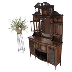 an old fashioned wooden desk with mirror and potted plant next to it on a white background