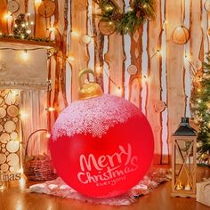 a large red christmas ornament sitting on top of a wooden floor