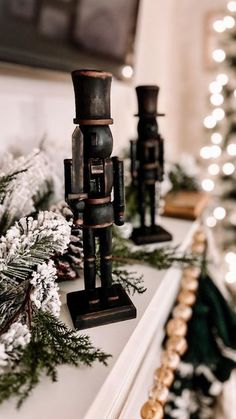 some candles are sitting on a mantle in front of a christmas tree