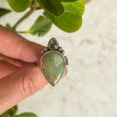 Truly beautiful Silver Peak Variscite teardrop along with a teardrop Madagascar Sapphire in similar green and gold tones. Both stones are wrapped in fine silver with sterling silver embellishments and band. Sits on a simple rectangular sterling silver band. Size 9 All of my work is hand crafted, from sourcing the stones from sustainable miners and lapidary artist, to forging the piece from sterling and fine silver sheet metal and wire. Over time, sterling silver develops a lovely patina, the mor Sterling Silver Multi-stone Teardrop Ring, Teardrop Chrysoprase Gemstone Jewelry, Green Teardrop Gemstone Accents Jewelry, Green Pear-shaped Sterling Silver Jewelry, Green Teardrop Gemstone Jewelry, Green Teardrop Jewelry With Gemstone Accents, Silver Teardrop Emerald Ring Gift, Silver Teardrop Ring With Gemstone Accents, Soft Jewelry