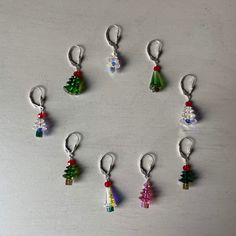 a bunch of small christmas tree charms on a table