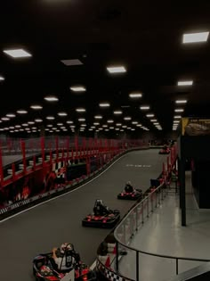 three go - kart racing cars in a race track with lights on the ceiling