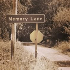 an old photo of a road sign and stop sign on the side of a dirt road