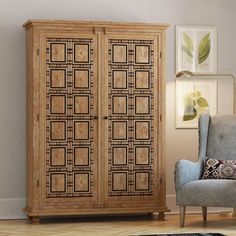 an armoire in the corner of a room with a chair and rug on the floor