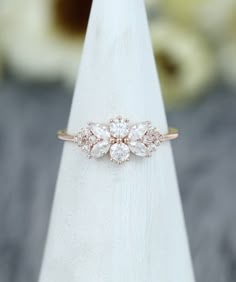 a diamond ring sitting on top of a white piece of paper with flowers in the background