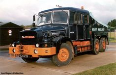 an orange and black truck is parked on the street