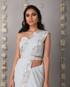 Description: The Classic Silhouette of a saree in ice blue, overlaid with whimsical details of a floral trellis border of hues of cream and silver. The saree is paired with a plain corset tube top blouse and embroidered belt.Colour Ice blueFabric GeorgetteCare Dry Clean onlyFit Tailored*Please note: The belt is included in the outfit Fitted Light Blue Blouse Piece For Wedding, Silver Fitted Pre-draped Saree With Zari Work, Fitted Silver Pre-draped Saree With Zari Work, Fitted Silver Pre-draped Saree For Designer Wear, Light Blue Pre-draped Saree For Wedding, Silver Pre-draped Saree With Sheer Dupatta, Elegant Light Blue Unstitched Blouse Piece, Fitted Silver Pre-draped Saree With Unstitched Blouse, Traditional Fitted Silver Pre-draped Saree