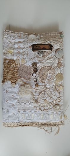 a white piece of cloth with buttons and lace on it sitting on top of a table