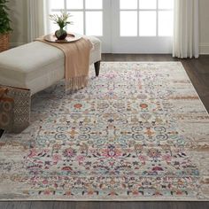 a living room with a large rug on the floor next to a chair and window