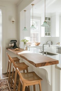 a kitchen with an island and stools in front of the counter top that is made out of wood