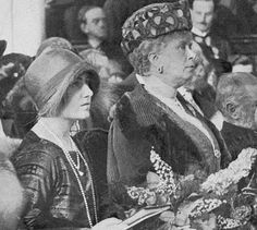 an old black and white photo of two women sitting next to each other with hats on