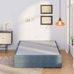 a bed with a blue mattress sitting on top of it in a bedroom next to a dresser